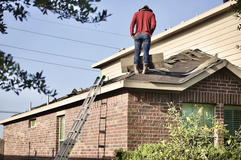Professional roofer working on a residential roof in Wilkinsburg